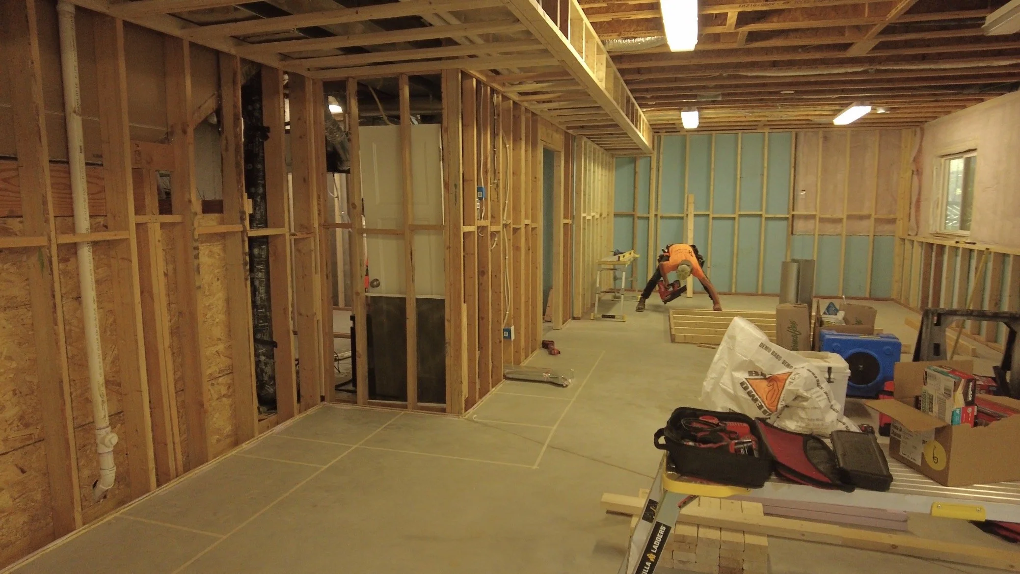 Basement with exposed ceiling joists and wood framing before drywall and finishing