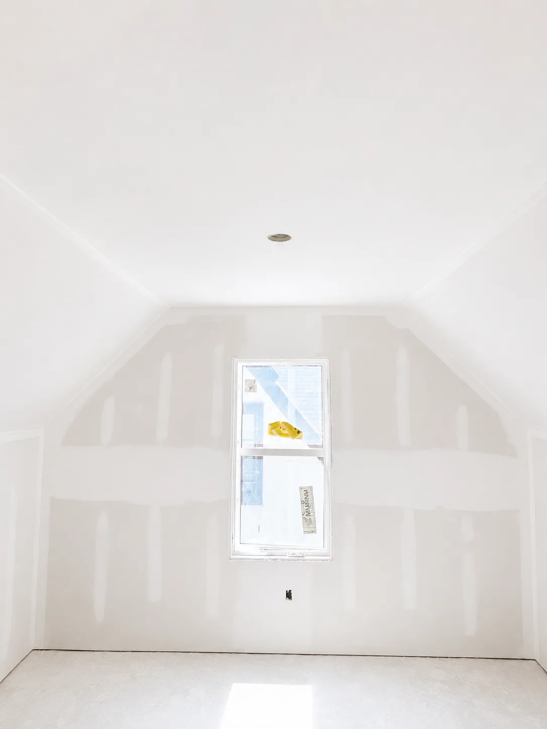A taped and finished drywall room with a centered window, ready for paint in a Prior Lake home