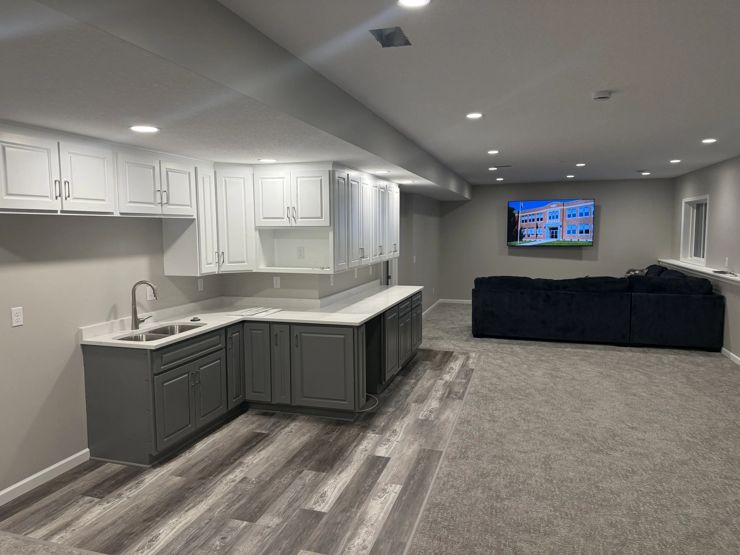 Finished basement with built-in cabinetry, fresh trim, paint, and new flooring