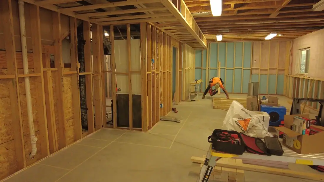 Basement with exposed ceiling joists and wood framing before drywall and finishing