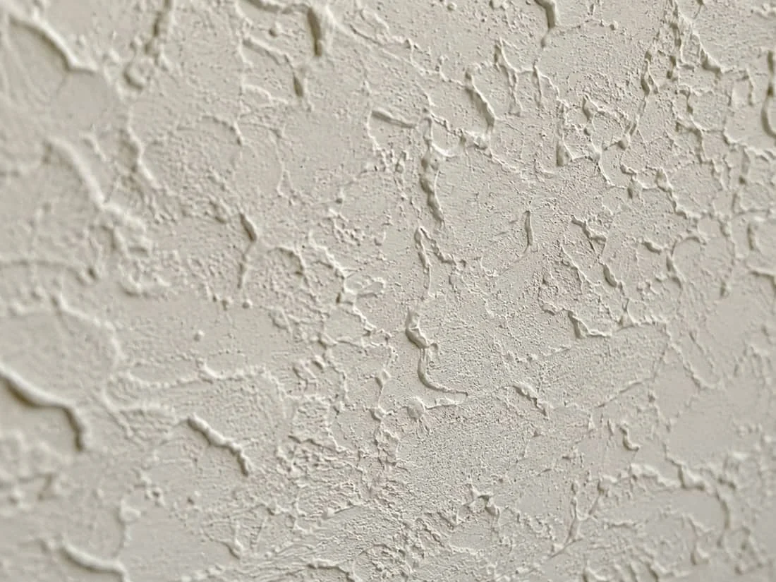 Close-up macro of a freshly applied knockdown ceiling texture