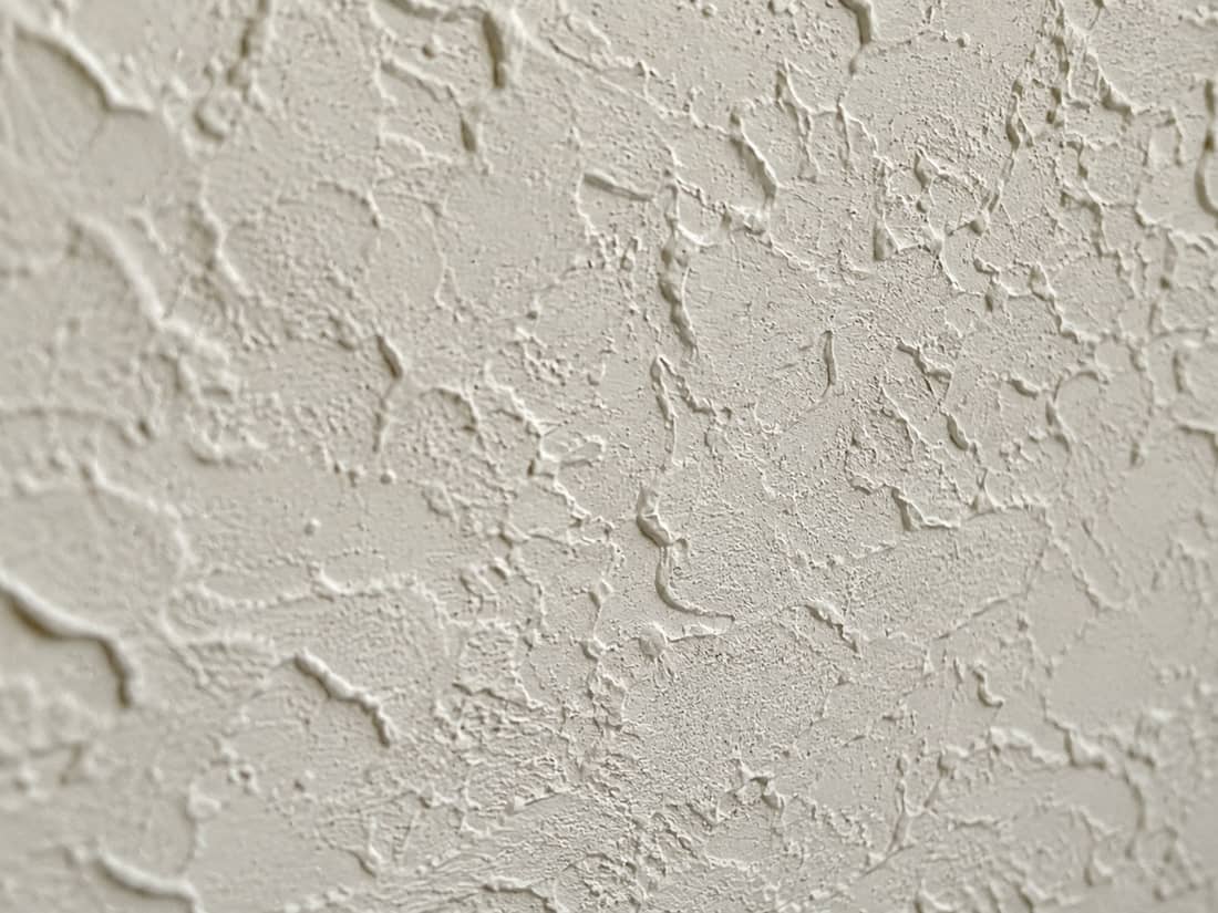 Close-up macro of a freshly applied knockdown ceiling texture