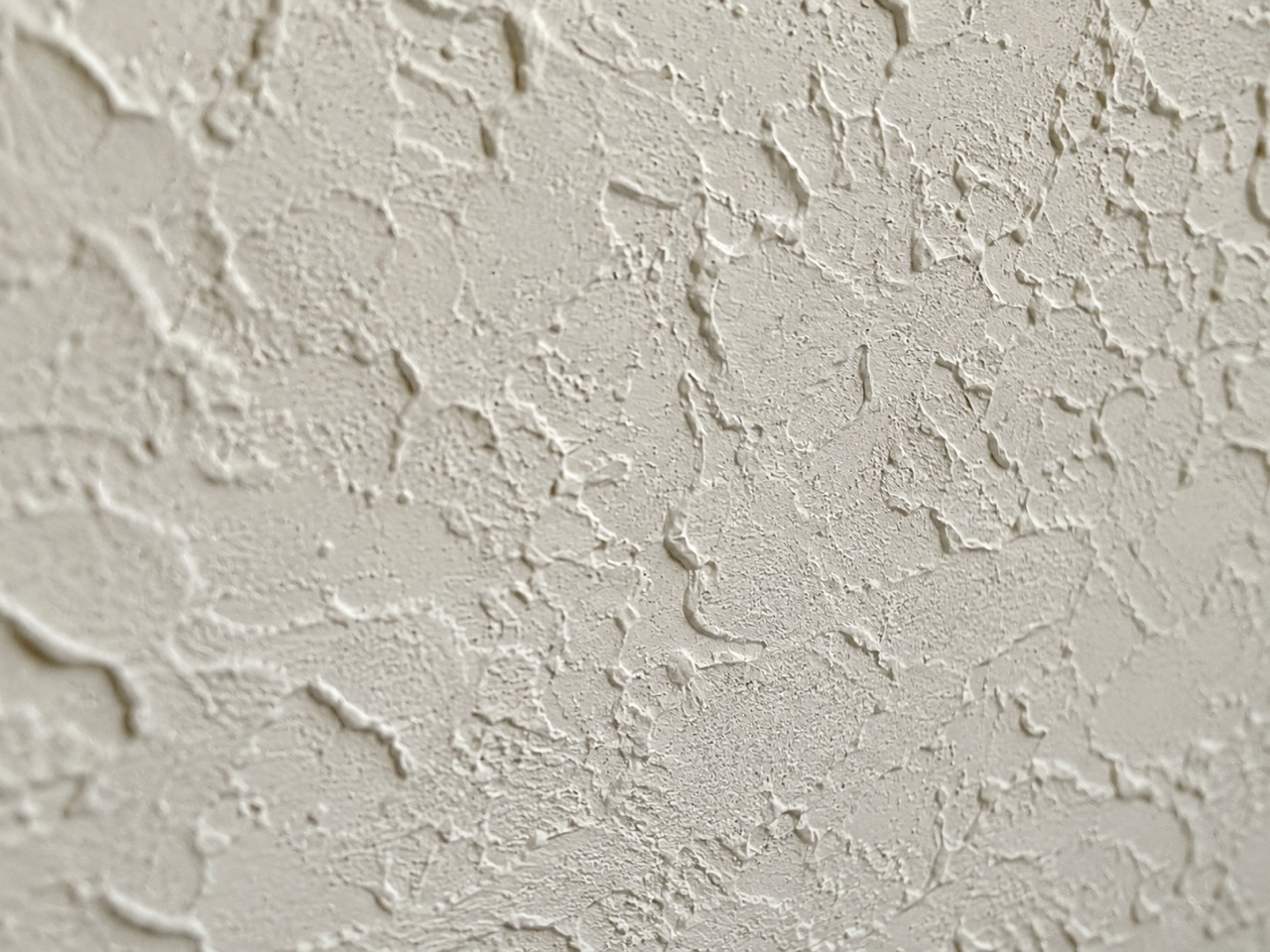 Close-up macro of a freshly applied knockdown ceiling texture